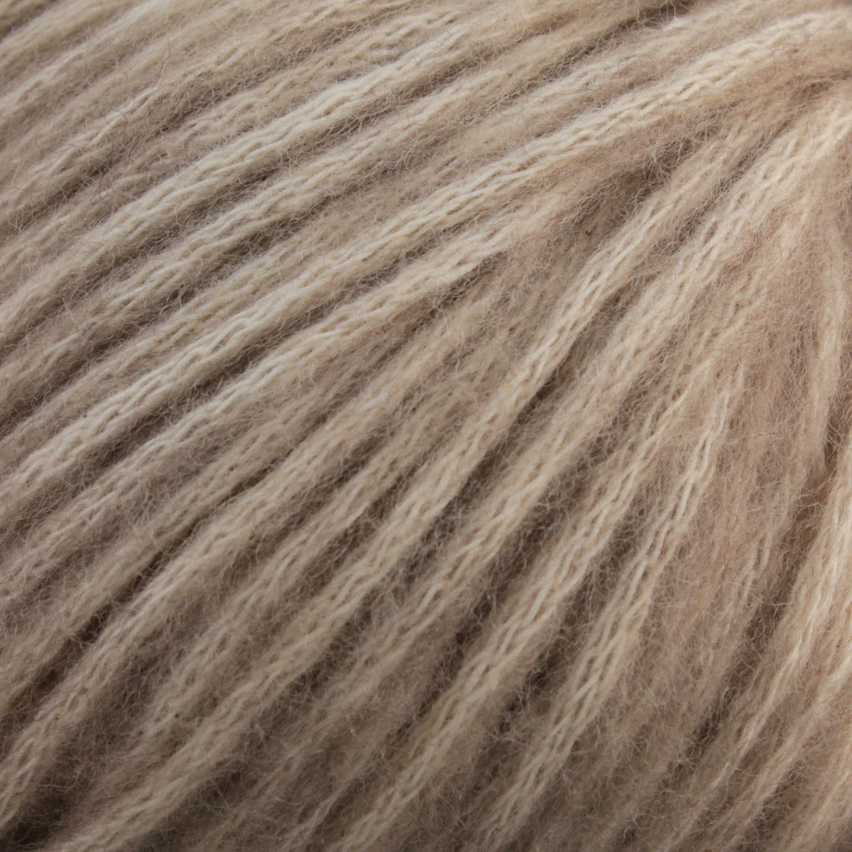 Close-up of Katia Cotton-Merino yarn by Katia, highlighting its soft beige fibers, visible individual strands, and slightly fuzzy texture.