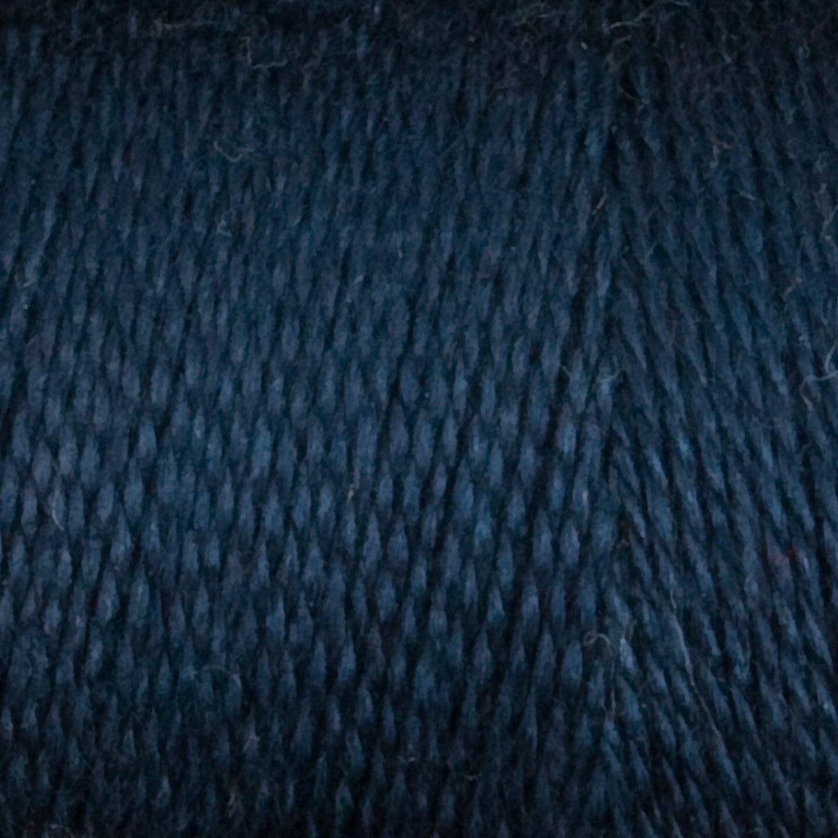 Close-up of Maurice Brassard 8/2 Tencel Yarn | Mini-cone in dark blue, highlighting its tightly twisted fibers and subtle texture—perfect for weaving projects.