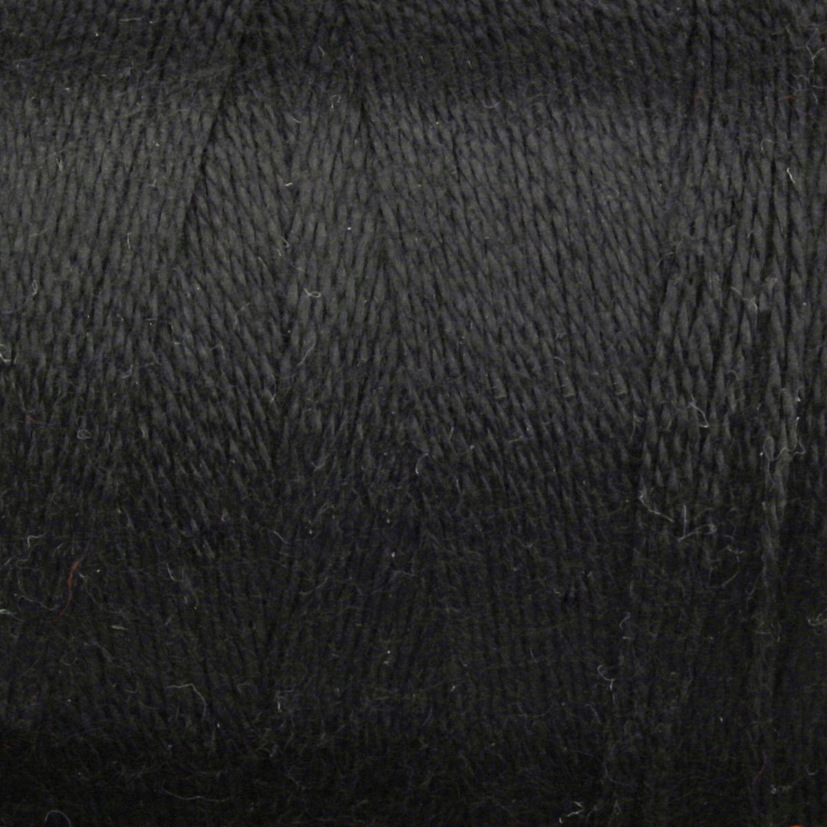 Close-up of tightly wound black Maurice Brassard 8/2 Tencel Yarn on a mini-cone, showing the textured fine cellulose fibers in overlapping layers—ideal for detailed weaving projects.
